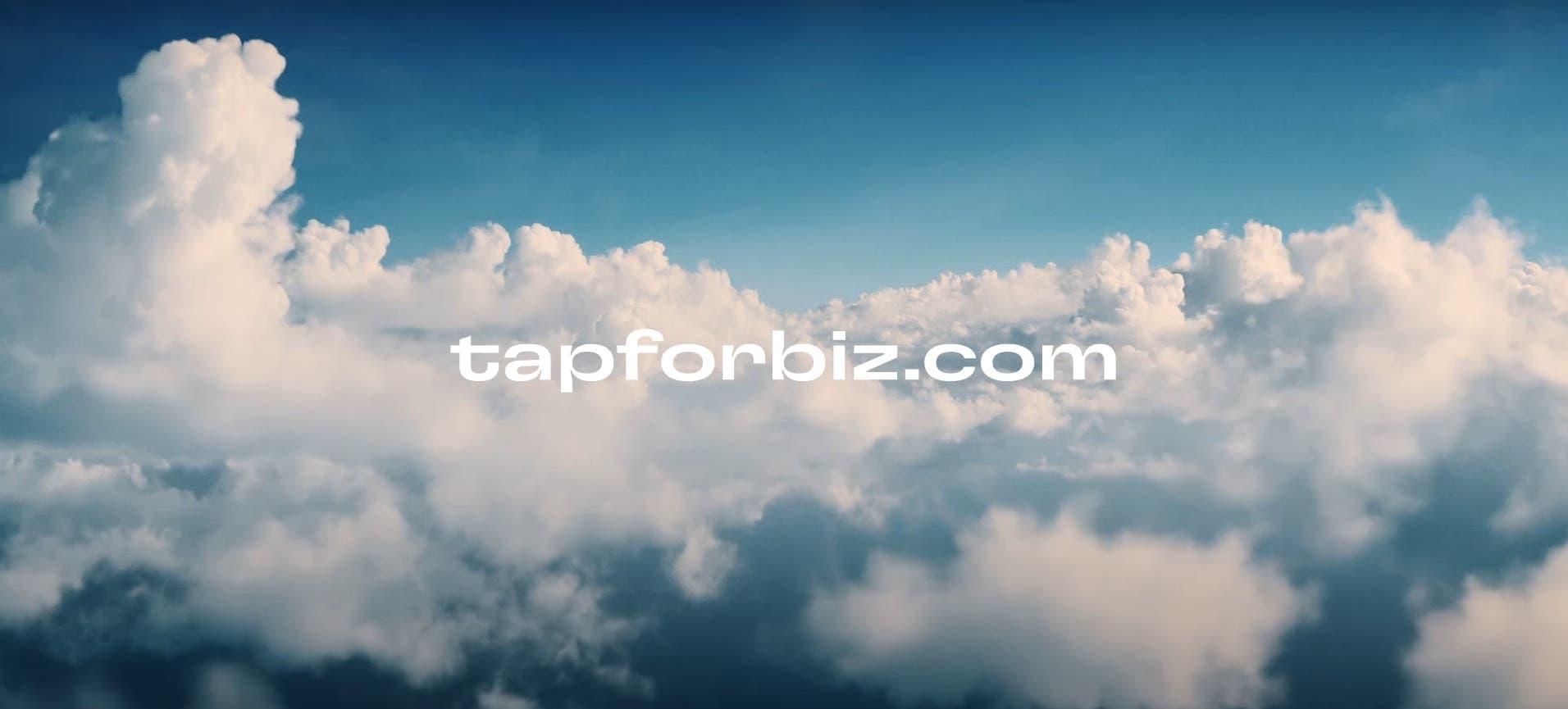 Vista de nuvens brancas fofas abaixo de um céu azul claro, com o texto "tapforbiz.com" ao centro Vista de nuvens brancas fofas abaixo de um céu azul claro, com o texto "tapforbiz.com" ao centro